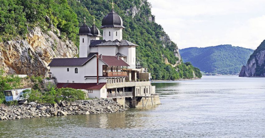 River Cruise - White and Black House Located at Riverside on Mountain Slope at Daytime